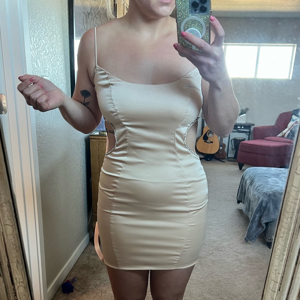 Cream/gold mini dress with cutouts outlined in diamonds.